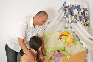 familia joven jugando con un lindo bebé foto