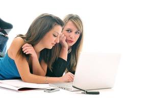 dos chicas jóvenes trabajan en una laptop aislada foto