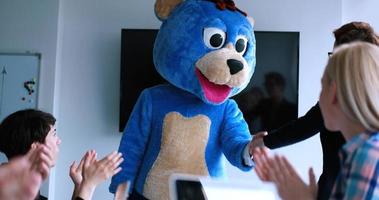 boss dresed as bear having fun with business people in trendy office photo