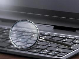 laptop computer with magnifying glass search concept photo