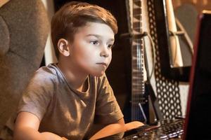 Small boy using laptop at home. photo