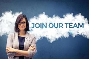 Join our team. Confident businesswoman with arms crossed standing next to sign on the wall. Job search concept. photo