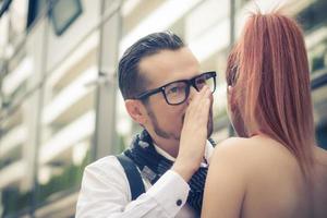 hombre susurrando un secreto a una mujer. foto