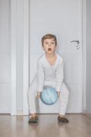 niño jugando con pelota en casa. foto