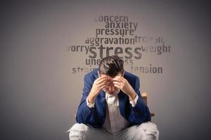 Overworked businessman having headache due to stress at work. photo