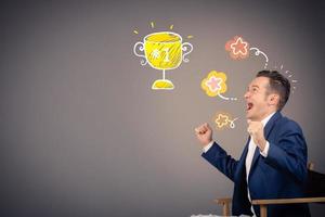Excited businessman celebrating success and screaming at winning trophy. Copy space. photo