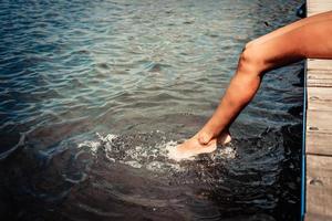 mujer irreconocible relajándose en un muelle. foto