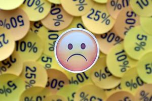 ternopil, ucrania - 8 de mayo de 2022 pegatina emoji infeliz en una gran cantidad de pegatinas amarillas con valores porcentuales para el viernes negro o el lunes cibernético foto