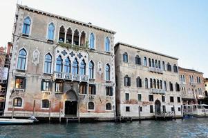 Classic Venice channel view with typical buildings, colorful windows, bridges and boats photo