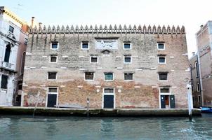 vista clásica del canal de Venecia con edificios típicos, ventanas coloridas, puentes y barcos foto