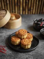 High view angle of traditional mid autumn mooncakes on black plate and uneven color grey table, with bamboos background. photo