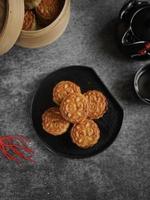 Top view angle of traditional mid autumn mooncakes on black plate and uneven color grey table. photo