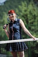 young woman play tennis game outdoor photo