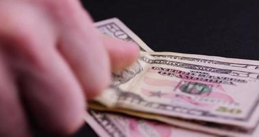 counting American fifty-dollar bills on black paper photo