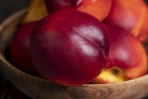 Nectarines folded in a wooden bowl photo