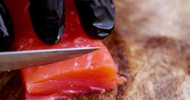 cutting red salted salmon into pieces during cooking photo