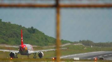 PHUKET, THAILAND NOVEMBER 26, 2016 - Airbus A320 of AirAsia picking up speed before takeoff at Phuket Airport HKT. View of the airfield and taxiways through the airport fence video