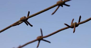 Old barbed wire against the blue sky photo