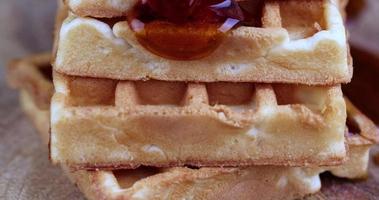 soft waffles that drain natural bee honey on a serving board photo