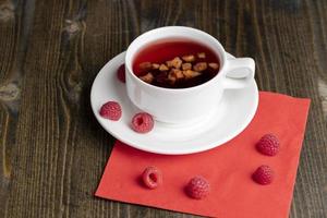Red raspberry tea with pieces of fruit and berries photo