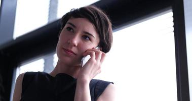 Business Girl Standing In A Modern Building Near The Window With Phone photo