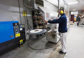 carpenter calculating and programming a cnc wood working machine photo