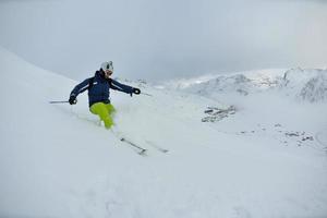 skiing on fresh snow at winter season at beautiful sunny day photo