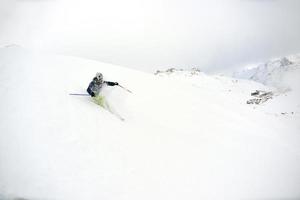 esquiar en nieve fresca en la temporada de invierno en un hermoso día soleado foto