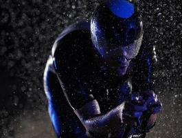 triathlon athlete riding bike  fast on rainy night photo