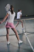 young girls playing tennis game indoor photo