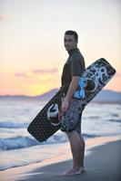 Portrait of a young  kitsurf  man at beach on sunset photo