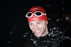 authentic triathlete swimmer having a break during hard training on night photo