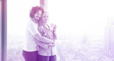 young couple enjoying morning coffee by the window photo