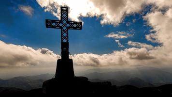 cruz no topo de uma montanha com nuvens em movimento video