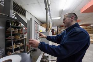 carpenter calculating and programming a cnc wood working machine photo