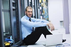 businessman with laptop in network server room photo