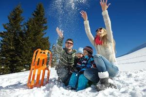 family having fun on fresh snow at winter photo