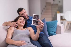 pareja embarazada mirando el ultrasonido del bebé foto