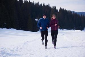 pareja trotando afuera en la nieve foto