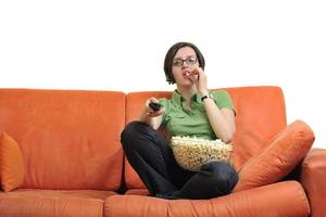 mujer joven come palomitas de maíz y ve la televisión foto