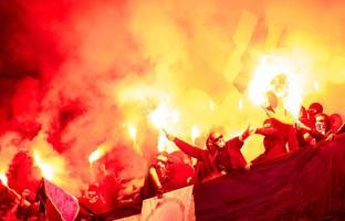 vándalos de fútbol con máscara sosteniendo antorchas en llamas foto