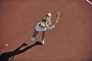 mujer joven jugar al tenis al aire libre foto