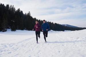 pareja trotando afuera en la nieve foto