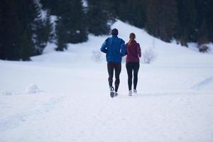 pareja trotando afuera en la nieve foto