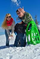 familia divirtiéndose en la nieve fresca en invierno foto