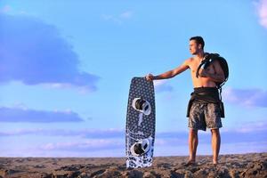 Portrait of a young  kitsurf  man at beach on sunset photo