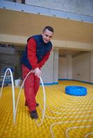 workers installing underfloor heating system photo