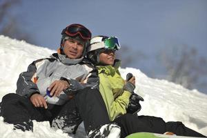 pareja de snowboarders relajante foto