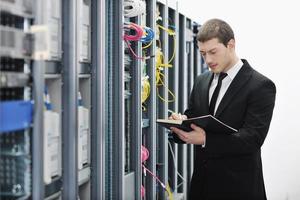 it businessman withnotebook in network server room photo