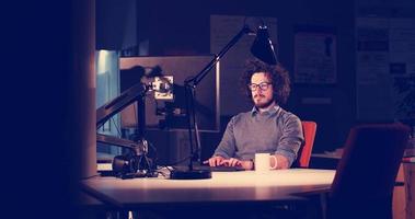 man working on computer in dark office photo